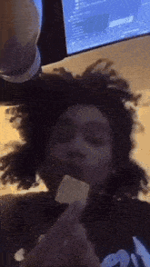 a person with dreadlocks is eating a piece of food