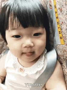 a baby in a car seat with the word yummy on the bottom right