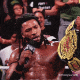 a man with dreadlocks is holding a wwe championship belt