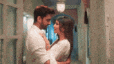 a man and a woman are standing next to each other in a hallway .