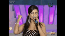 a woman singing into a microphone on a sony tv
