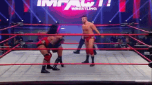 two men are wrestling in a wrestling ring with the word impact wrestling in the background