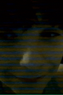 a close up of a person 's face in the dark with a blurred background .