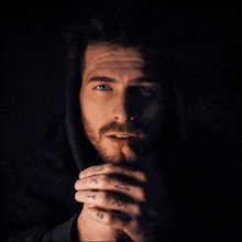 a man with a beard has a tattoo on his finger that says ' x '