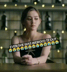 a woman in a black dress is sitting at a table with a caption that says even she was weirded tf out