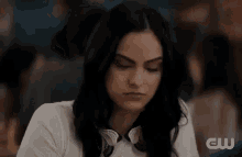 a woman is making a funny face while sitting at a table in a crowded room .