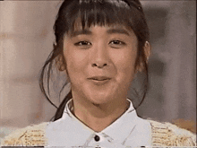a close up of a woman 's face with a white shirt on .