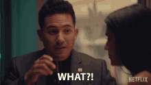 a man is talking to a woman and says " what "