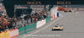 a race track with a sign that says rolex in the background