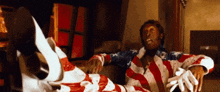a man in an american flag outfit sits on a chair