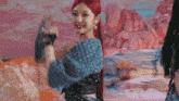 a woman with red hair is standing in front of a colorful background .