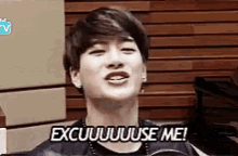 a young man is making a funny face and saying `` excuse me ! ''