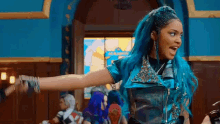 a woman with blue hair is dancing in a room .