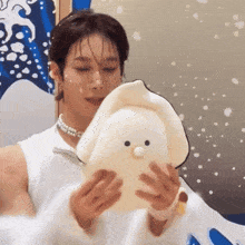 a person holding a stuffed animal with a bird face on it
