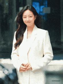 a woman in a white suit is smiling with the word hyundai on the bottom left