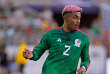 a soccer player with pink hair wears a green jersey with the letter n on it