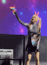 a woman stands on a stage in front of a radiance case