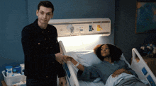a man stands next to a woman in a hospital bed