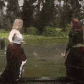 two women standing next to each other in a puddle of water