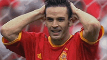a man wearing a red jersey with a spanish flag on the front