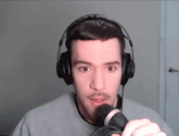 a man wearing headphones holds a microphone in front of his face