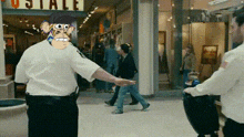 a man with a monkey on his head is standing in front of a store that says postale