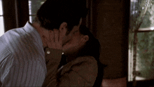 a man and a woman are kissing in a dark room