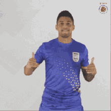 a man wearing a blue shirt that says ' india ' on it gives a thumbs up