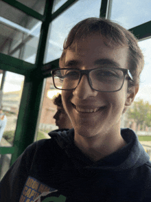 a young man wearing glasses and a sweatshirt that says iron man