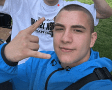 a young man wearing a blue jacket and a white shirt that says gk 12