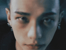 a close up of a man 's face with earrings on his ear