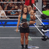 a woman in a wrestling ring holds up a sign that says livorn ripmy