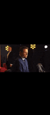 a man in a suit and tie is talking to another man in a suit