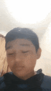 a young boy with his eyes closed is wearing a black shirt