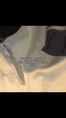 a close up of a white jacket with a zipper and a foreign language written on it