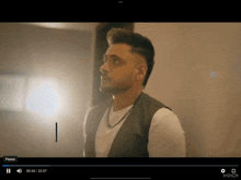 a video of a man with a pause button on the bottom left