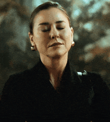 a woman with her eyes closed is wearing earrings