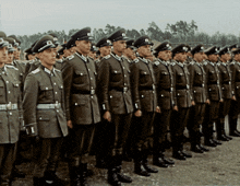 a group of soldiers are lined up in a row with the letter i on their uniforms