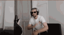 a man wearing headphones and sunglasses is dancing in a living room