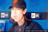 a pixelated image of a man wearing a sf baseball cap