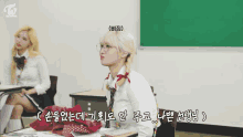 two girls are sitting at desks in a classroom with a green board that says twice on it