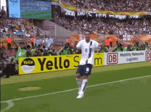 a soccer player with the number 8 on his jersey runs on the field