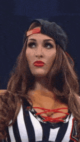 a close up of a woman wearing a baseball cap and a lace up top .