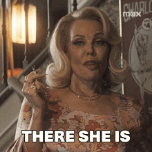 a woman smoking a cigarette with the words there she is below her