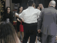 a man in a suit is dancing with a woman in a red skirt