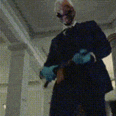 a man in a suit and mask is holding a gun in a hallway