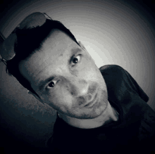 a man wearing sunglasses looks at the camera with a serious look on his face