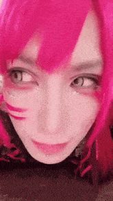 a close up of a person 's face with pink hair and piercings .
