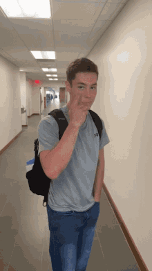 a young man wearing a grey under armour shirt giving the middle finger
