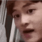 a close up of a man 's face with a surprised look on his face .